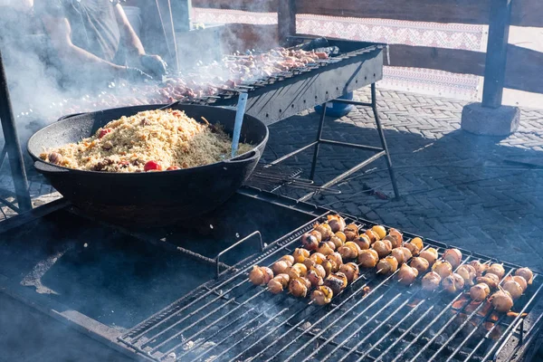 Pilaf y patatas con tocino a la parrilla en un festival de comida callejera —  Fotos de Stock