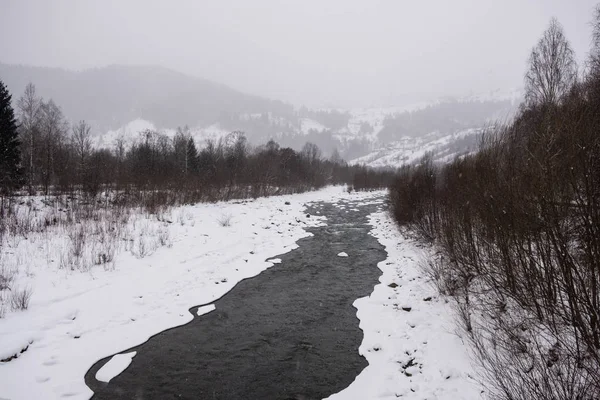 Calma y acogedor pueblo de cuento de hadas Kryvorivnia cubierto de nieve en las montañas de los Cárpatos, vista aérea . Fotos De Stock