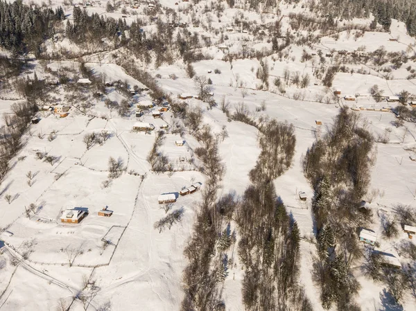 Calma y acogedor pueblo de cuento de hadas Kryvorivnia cubierto de nieve en las montañas Cárpatos, vista aérea. Paisaje típico en el Parque Nacional Hutsulshchyna en Ucrania. Vacaciones y deportes de invierno . Imágenes De Stock Sin Royalties Gratis