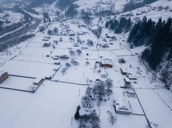 Calma y acogedor pueblo de cuento de hadas Kryvorivnia cubierto de nieve en las montañas Cárpatos, vista aérea. Paisaje típico en el Parque Nacional Hutsulshchyna en Ucrania. Vacaciones y deportes de invierno . Fotos De Stock Sin Royalties Gratis