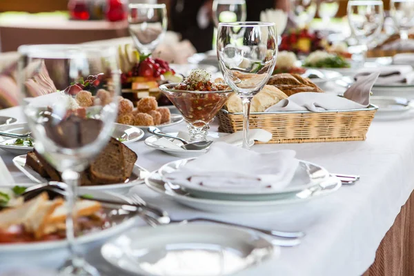 Servido para mesa de restaurante banquete com pratos, lanche, vinho e copos de água, comida europeia — Fotografia de Stock