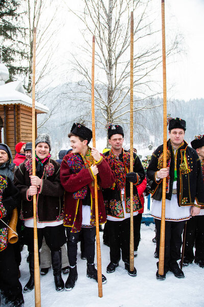 Famous hutzulian Koliadnyky in national Hutsul costume singing Christmas carols and playing on traditional trembita horn, Carpathian village Kryvorivnia