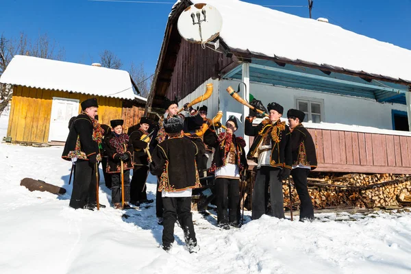 Famoso hutzulian Koliadnyky em traje Hutsul nacional cantando canções de Natal e tocando no chifre de trembita tradicional, aldeia dos Cárpatos Kryvorivnia — Fotografia de Stock