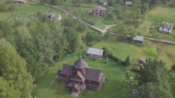 山の村で古い木造正教会への空中ウクライナのカルパチア山脈のクリヴォリニア Hutsulshyna国立公園の典型的な風景 — ストック動画
