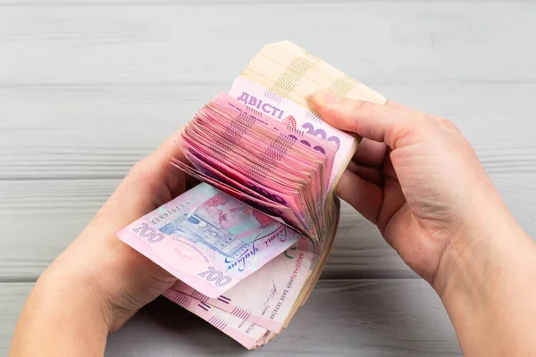 Пачка украинских гривен с банкнотами в руках — стоковое фото