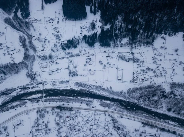 Village Kryvorivnia borított hó a Kárpátok hegyek, légi kilátás. Tipikus táj Hutsulshchyna Nemzeti Park Ukrajnában. Nyaralás és téli sportok. Stock Kép