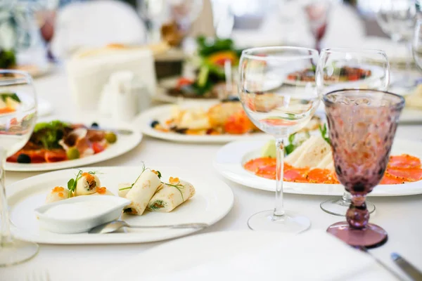 접시, 간식 , 커 틀리지 , 포도주와 물 잔 , 유럽 음식, 선택적 인 집중을 갖춘 연회 식탁에서 제공되었다 — 스톡 사진