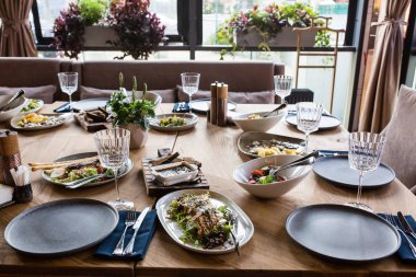 Tabaklar, atıştırmalıklar, şarap ve su bardakları ve Avrupa yemekleriyle birlikte ziyafet masasında servis ediliyor.