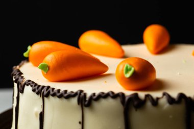 homemade cake with carrot decor on black background clipart