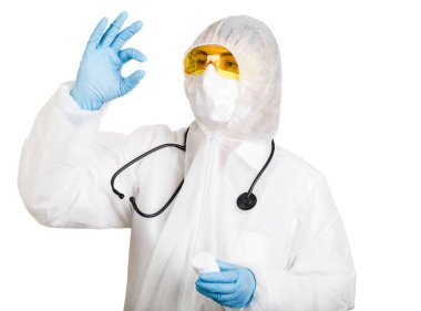 Maske ve gözlük takan tek kullanımlık anti-salgın takım elbiseli doktor hapları beyaz arka planda tutuyor.