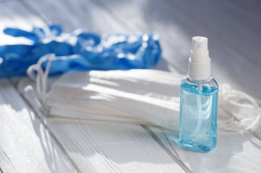 El antibakteriyel antiseptik jel, yüz maskesi, tahta masa üzerinde lastik eldivenler. Grip salgını konsepti sırasında Coronavirus Hastalığı Covid-19 önleme ve sağlık koruma