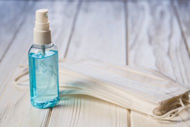El antibakteriyel antiseptik jel, beyaz tahta masada yüz maskesi. Coronavirus Hastalığı (Covid-19) grip virüsü salgını sırasında önleme ve sağlık koruma