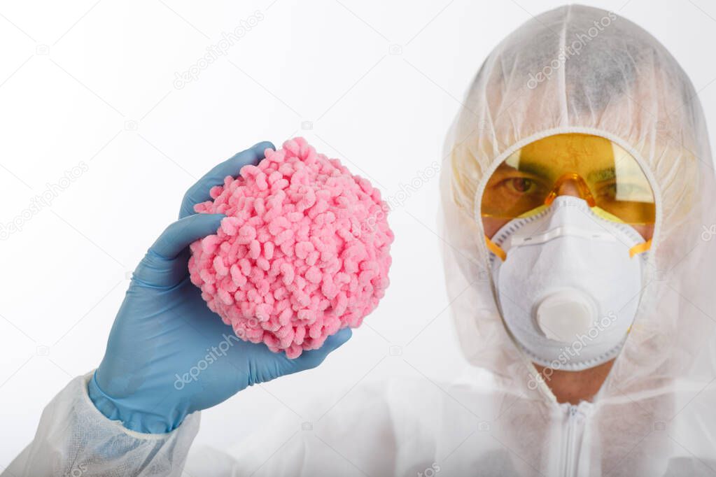 Doctor in anti-epidemic suit and respirator hold wool ball like coronavirus on white background