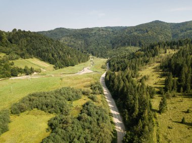 Dağların tepesinden çekilen orman ve dağlarla dolu güzel bir hava manzarası.