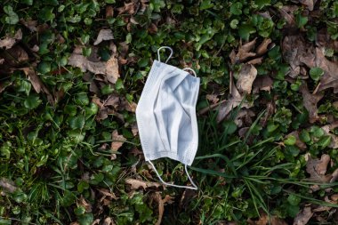 Çimenlerdeki enfeksiyonlara karşı korunmak için kullanılmış tıbbi maske.