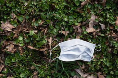 Çimenlerdeki enfeksiyonlara karşı korunmak için kullanılmış tıbbi maske.