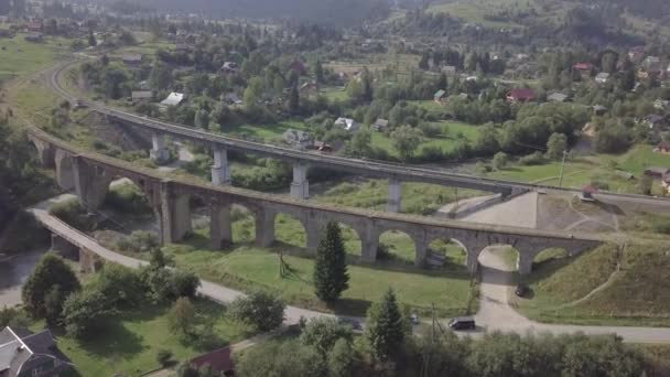 ヴォロフタ村 ウクライナのカルパティアの古い高架橋鉄道の交差点への航空 川の水と橋 — ストック動画