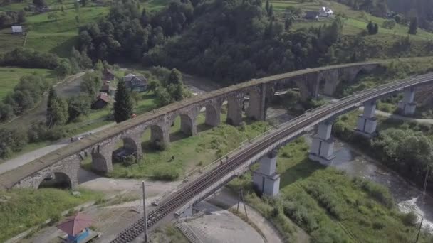 ヴォロフタ村 ウクライナのカルパティアの古い高架橋鉄道の交差点への航空 川の水と橋 — ストック動画