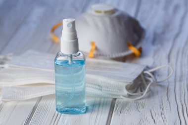 El antibakteriyel antiseptik jel, yüz maskesi ve solunum cihazı beyaz tahta masada. Coronavirus Hastalığı (Covid-19) grip virüsü salgını sırasında önleme ve sağlık koruma