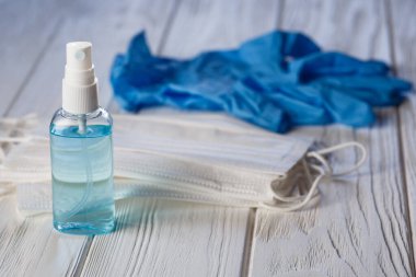 El antibakteriyel antiseptik jel, yüz maskesi, tahta masa üzerinde lastik eldivenler. Coronavirus Hastalığı (Covid-19) grip virüsü salgını sırasında önleme ve sağlık koruma
