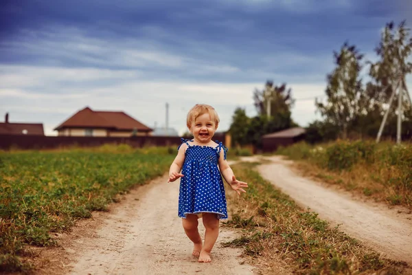 1岁的小女孩赤脚走在乡间小路上。. — 图库照片