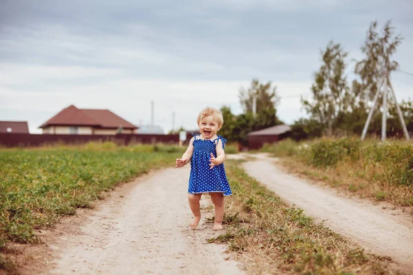 1.在乡间路上光着脚的1岁女孩. — 图库照片