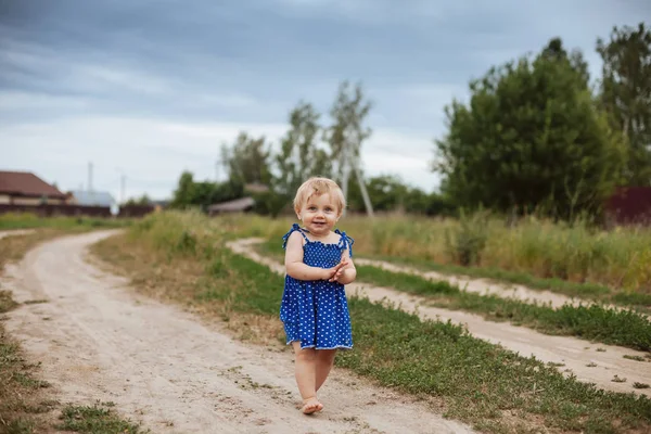 Toddler女孩赤脚走在乡村道路上. — 图库照片