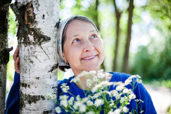 Anziana donna in sciarpa bianca contro la natura . — Foto Stock