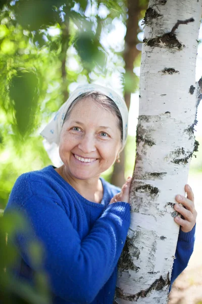 Ηλικιωμένη γυναίκα με λευκό μαντήλι κατά της φύσης. — Φωτογραφία Αρχείου