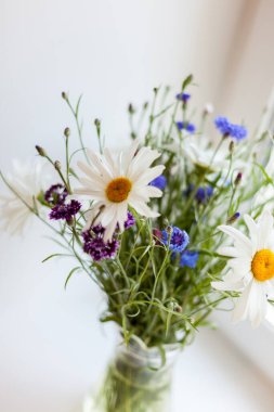 Penceredeki vazoda bir buket yabani çiçek..