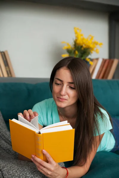 Молода Жінка Читає Книгу Вдома Дивані — стокове фото