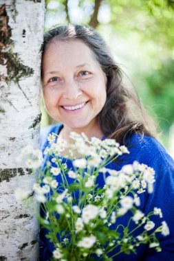 Yazın huş ağacının yanında güzel olgun bir kadının portresi..