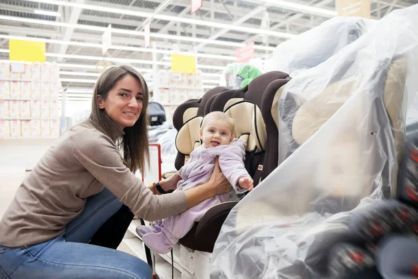Joven Madre Con Hija Pequeña Eligiendo Asiento Coche Tienda Productos —  Fotos de Stock