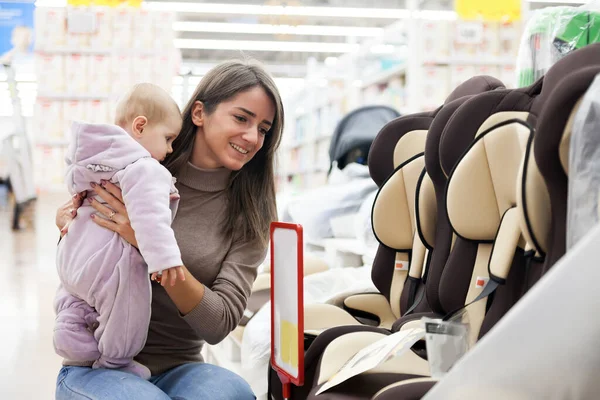 Fiatal Anya Kislányával Autóülés Kiválasztása Gyermekáruk Tárolására — Stock Fotó