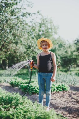 Çocuk yataklara dikmek ve sulamak ile ilgileniyor.