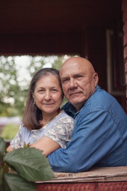 Yaz günü balkonda yaşlı bir çiftin portresi. 