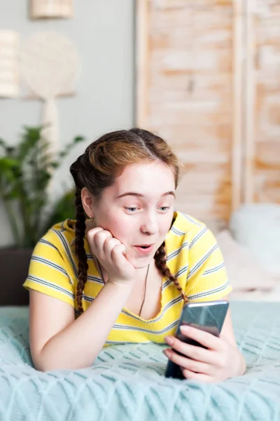 Portrait of   teenager on   bed with mobile  at home.