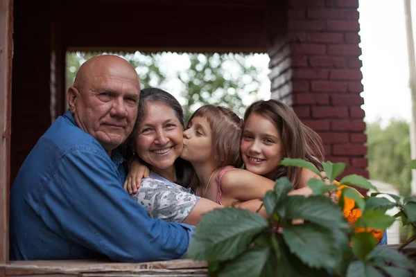 Happy Grandparents Hugging Granddaughters Verandah Country Cottage — Stock Photo, Image