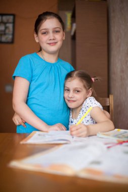 Evde ev ödevi yapan kız kardeşler uzaktan öğrenme üzerine..