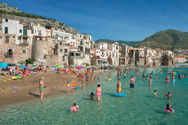 Persone non identificate sulla spiaggia sabbiosa di Cefalu, Sicilia, Italia — Foto Stock