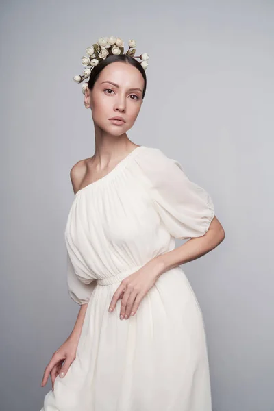 Mujer en vestido griego blanco con flores en la cabeza — Foto de Stock