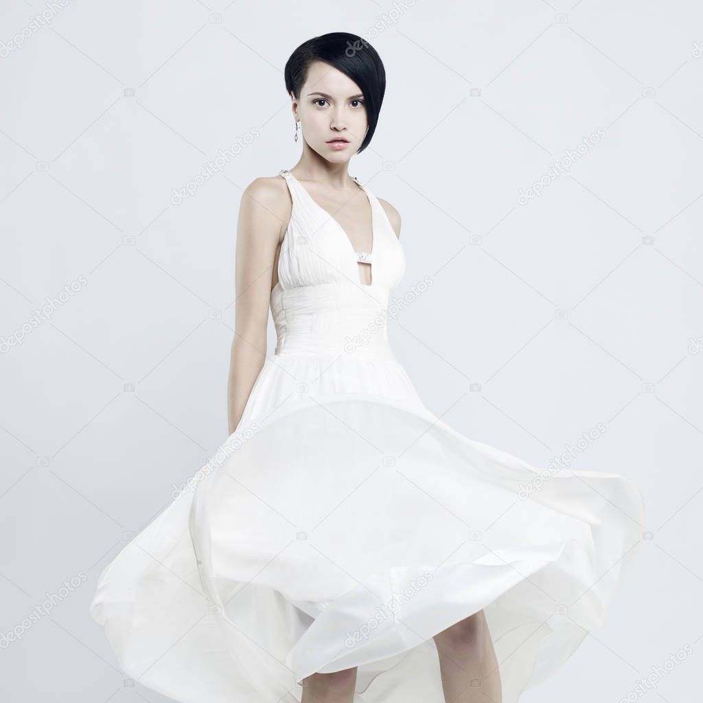 Fashionable photo of beautiful young woman in billowing white dress