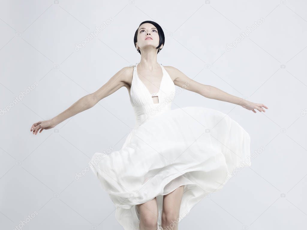 Fashionable photo of beautiful young woman in billowing white dress