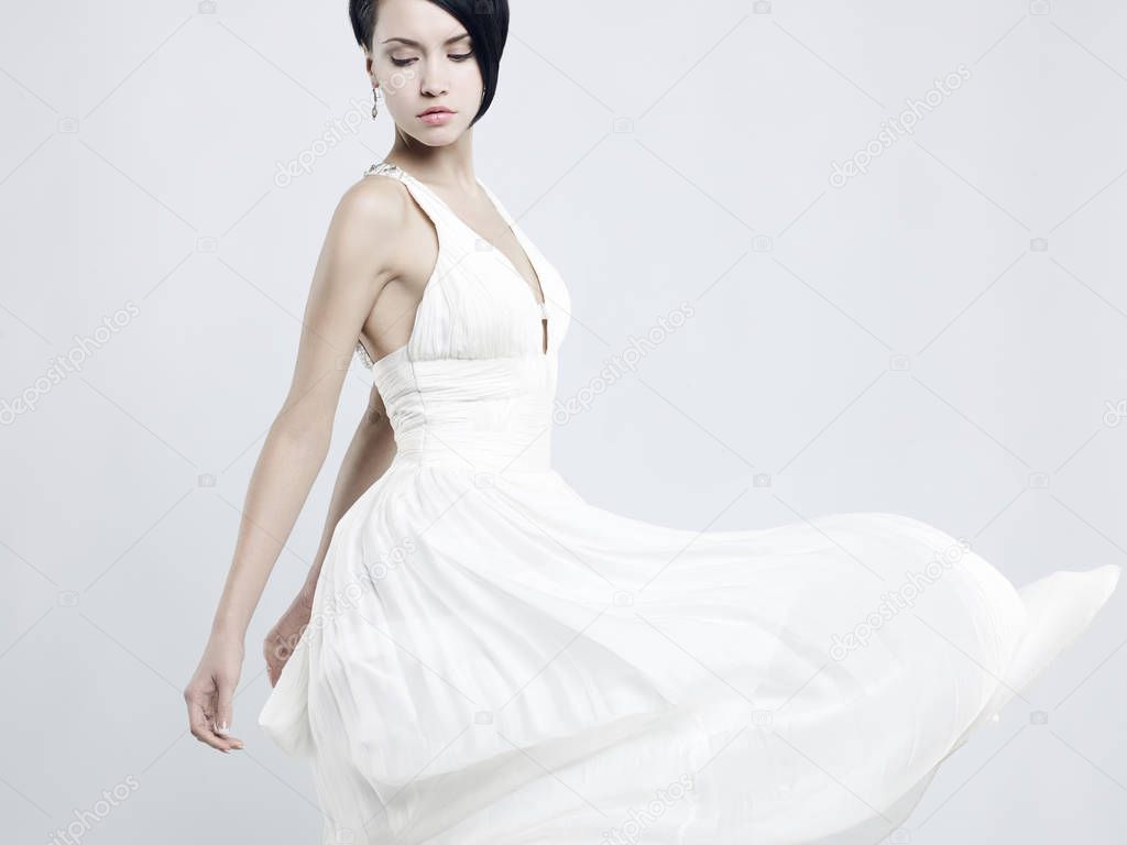 Fashionable photo of beautiful young woman in billowing white dress