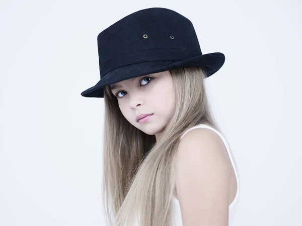 黒の古典的な帽子のかわいい女の子 白いドレスの子供のスタジオファッション写真 白を基調とした美しいモデル — ストック写真