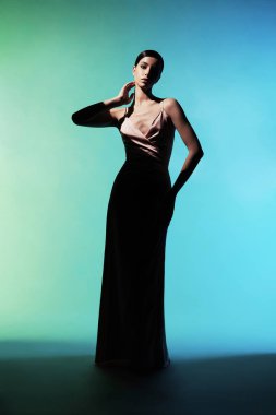 Zarif, şık elbiseli bir kadın. Stüdyoda pembe gece kıyafetleri içinde güzel bir model. Klasik ipek elbise. Seksi bayan beyaz arka planda kalsın. Klasik saç stili ve makyajlı mükemmel bir genç kadın.. 