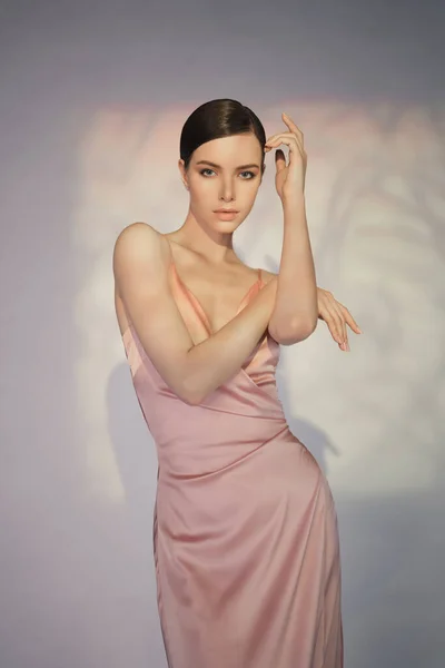 아름다운 모델은 분홍색 스튜디오에서 포즈를 취한다 전형적 드레스네요 여자는 배경을 — 스톡 사진