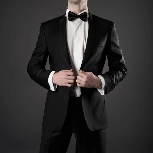 ネクタイでエレガントな黒のスーツのスタイリッシュな男の写真 写真スタジオでファッショナブルな若いモデルのポーズ 白いシャツを着た豪華な夜の喫煙 — ストック写真