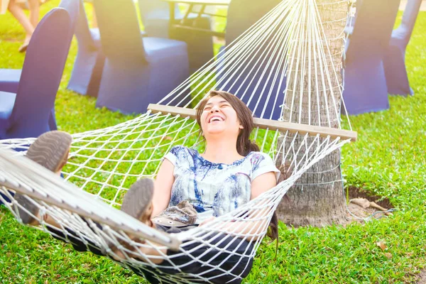 Laughing biracial teen girl relaxing in hammock — Stock Photo, Image