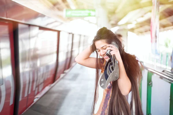 Tiener meisje met behulp van mobiele telefoon op platform treinstation — Stockfoto